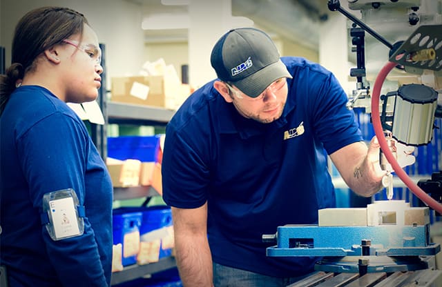 Youth apprentice learns machining with instructor