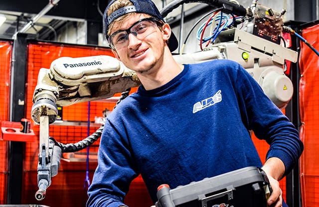 Youth apprentice operating robotic welder