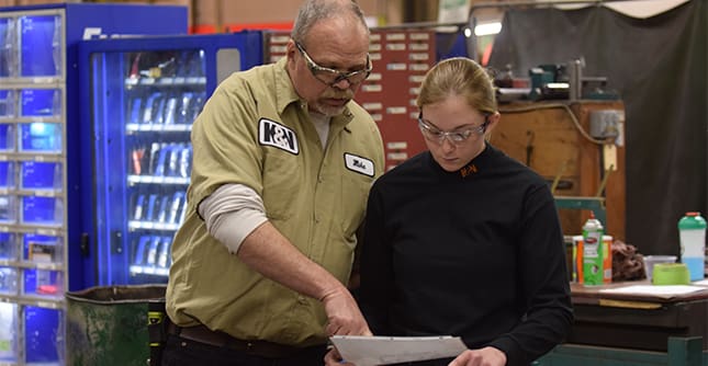AJAC Apprentice looks at a blueprint for machining
