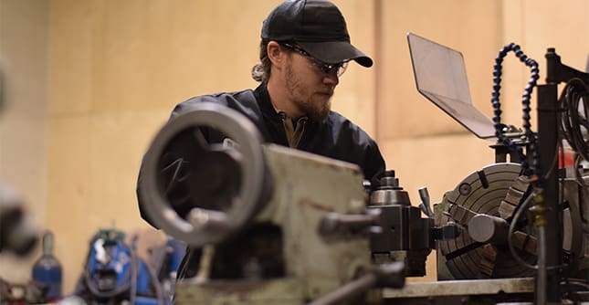 AJAC machinist apprentice using a manual lathe to machine a part