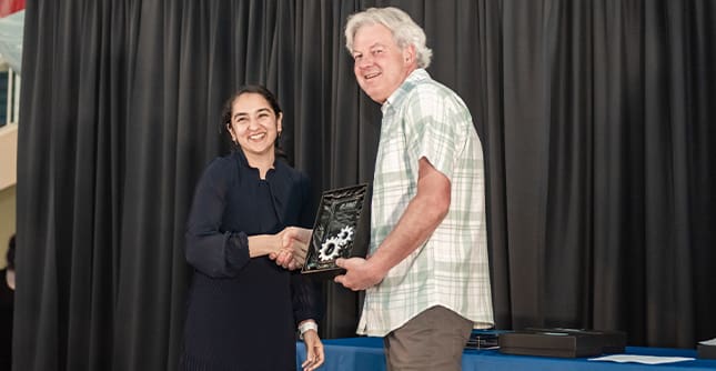 Jeff Kellers receives plaque from Deepti Dhir during graduation
