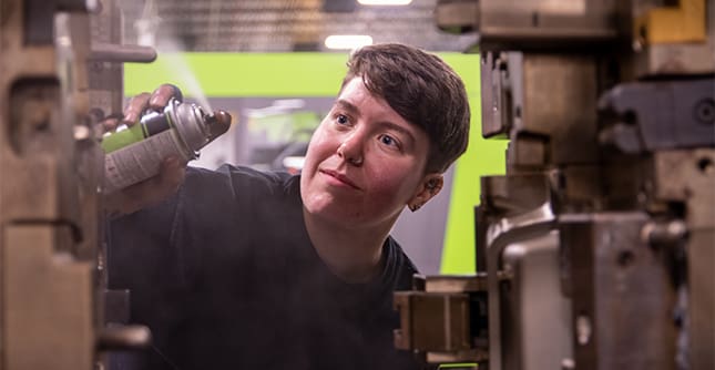 Grace applies lubricant to an injection molding machine