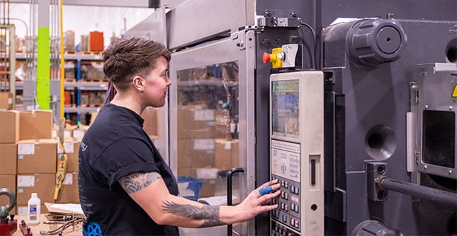 Grace operates an injection molding machine at Tool Gauge