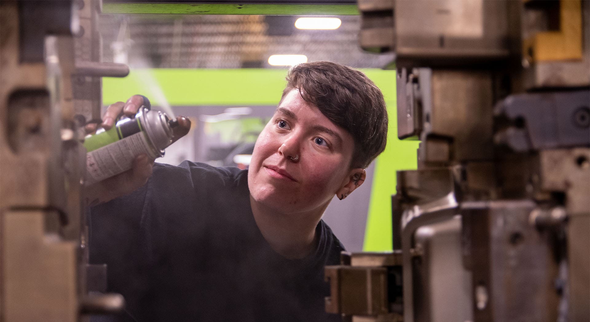 An apprentice works on a plastic injection molding machine in Tacoma, Washington.