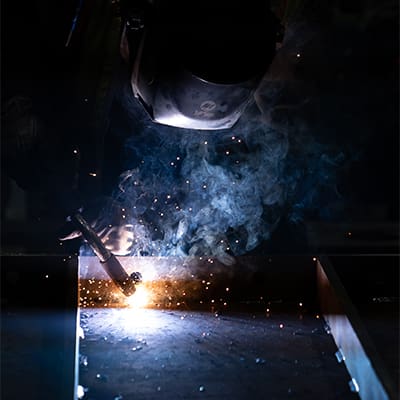 An AJAC Youth Apprentice at Sierra Pacific Industries welds metal in the fabrication shop