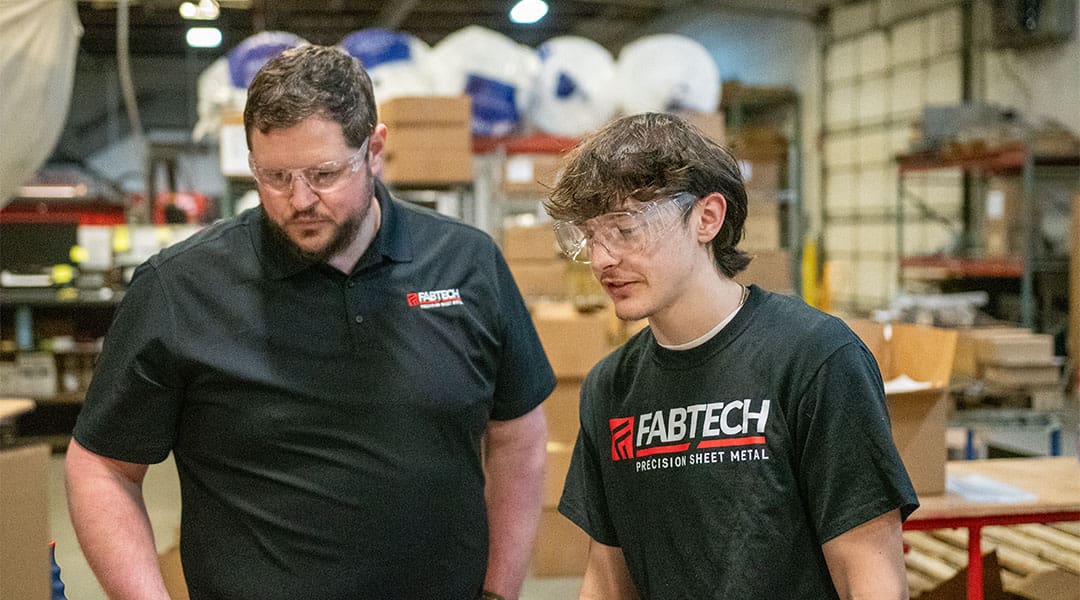 Matt Lynch from Fabtech Precision Sheet Metal works with an AJAC youth apprentice at the company.
